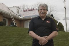 JP Roofing owner stands in front of house