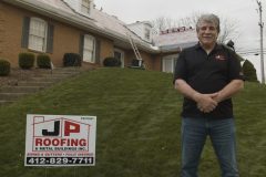 JP Roofing owner stands in front of house