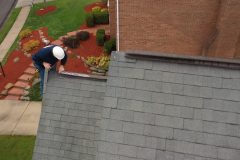 Roofing contractor works on roof