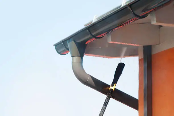 High pressure hose clearing out gutters